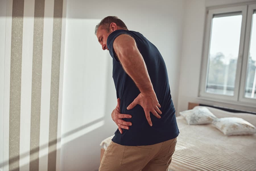 Man with Sore Hip in Bedroom