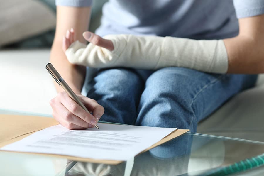 Woman signing document with broken arm